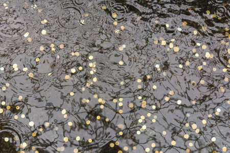 Coins thrown for luck at the bottom of the pool. Water with golden coins background.の写真素材