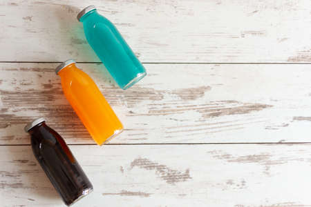 Isotonic energy drink. Bottles of sport beverage with diferent tastes and kombucha added on wooden background. Copy space.の写真素材