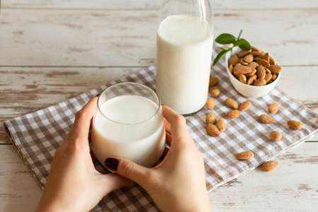 Fresh organic Almond milk in glass with almond nuts. Healthy eating concept.