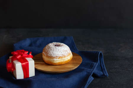 Hanukkah sufganiyot. Traditional Jewish donuts for Hanukkah with red jam and sugar powder. Holiday gift. Copy space.の写真素材