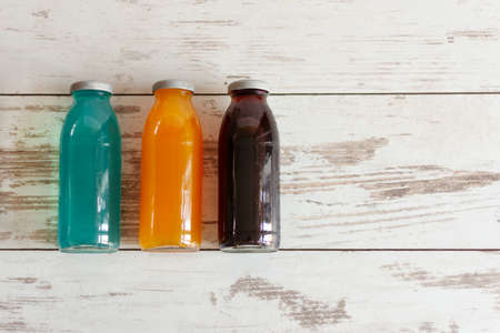 Isotonic energy drink. Bottles of sport beverage with diferent tastes and kombucha added on wooden background. Copy space.の写真素材
