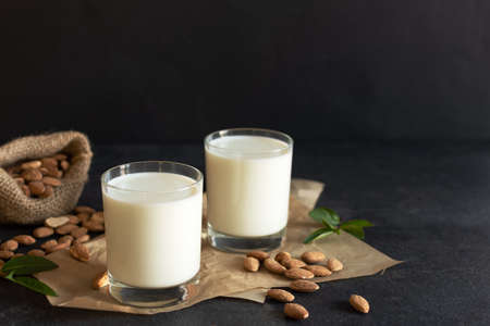 Fresh organic Almond milk in glass with almond nuts. Healthy eating concept.の写真素材