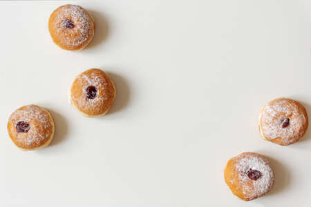 Hanukkah sufganiyah. Traditional Jewish donuts for Hanukkah with red jam and sugar powder top view. Copy space.の写真素材