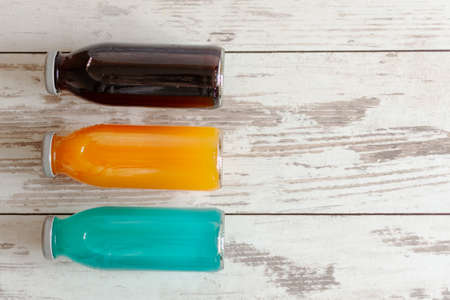 Isotonic energy drink. Bottles of sport beverage with diferent tastes and kombucha added on wooden background. Copy space.の写真素材