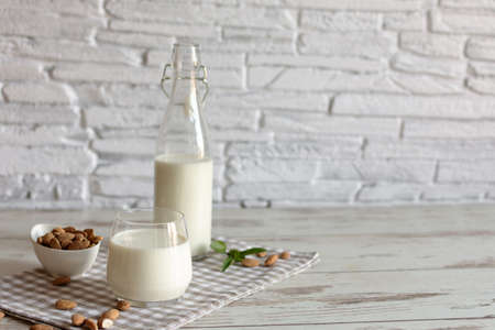 Fresh organic Almond milk in glass with almond nuts. Healthy eating concept.の写真素材