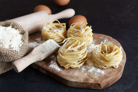 Raw homemade fettucine pasta on black background. Italian food cuisine.の写真素材