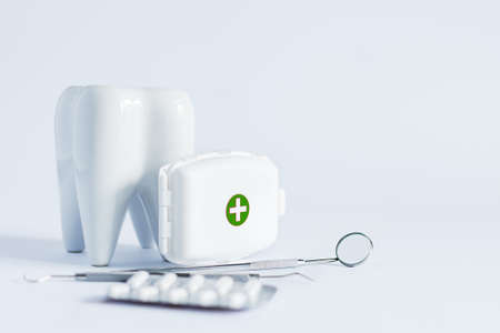 Model of white tooth, medical pills and dentistry tools on white background. Teeth treatment concept.の写真素材