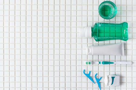 Toothbrush, mouthwash, dental floss, oral rinse top view on white mosaic background. Dental hygiene concept.の写真素材