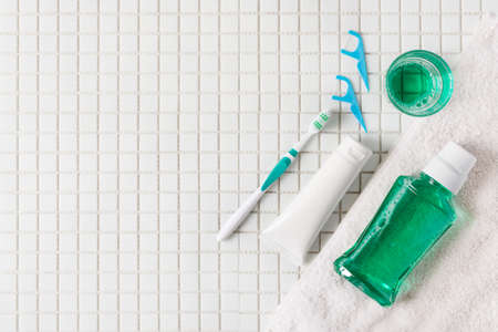 Toothbrush, mouthwash, dental floss, oral rinse top view on white mosaic background. Dental hygiene concept.の写真素材