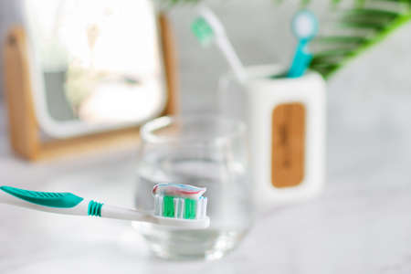 Toothbrush with toothpaste in the bathroom table with glass of water. Teeth hygiene concept.の写真素材