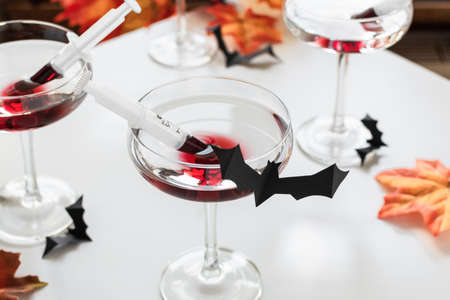 Bloody alcoholic cocktail with liqueur in a syringe. Halloween creative beverage.の写真素材