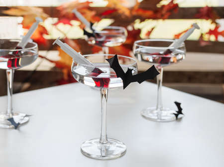 Bloody alcoholic cocktail with liqueur in a syringe. Halloween creative beverage.の写真素材
