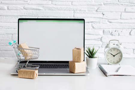 Boxes in a trolley on a table with  laptop in modern interior. Concept of online shopping.の写真素材