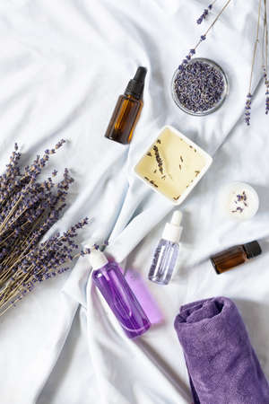Variety of organic lavender cosmetics on white background top view. Herbal cosmetics with lavender flowers.の写真素材