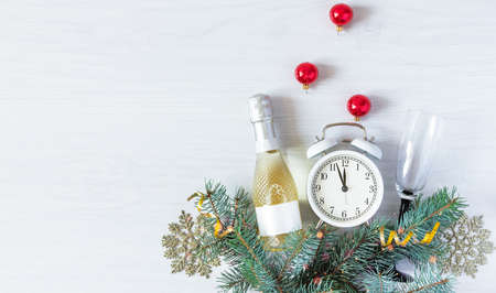 New Year's background with champagne bottle, fir branches and Christmas decorations on white wooden...