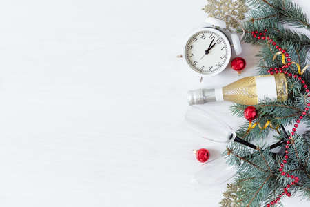 New Year's background with champagne bottle, fir branches and Christmas decorations on white wooden...