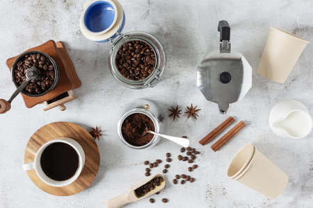 Ingredients and equipment for making coffee top view on grey background.