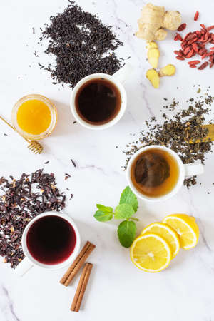 Green, black and red tea in a white ceramic cups top view. Different tea drink and ingredients top view.の写真素材