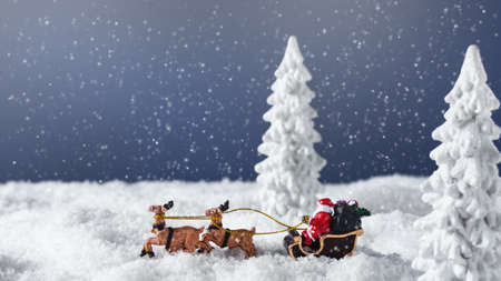 Santa Claus in a sleigh with reindeer in the snowy forest. Christmas greeting card.の写真素材