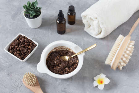 Homemade body scrub made with ground coffee, honey and oatmeal in a jar on gray concrete table. Self-care at home, eco homemade cosmetic for spa and skin care.の写真素材