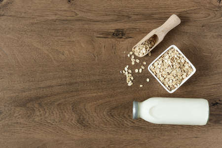 Homemade non dairy alternative milk made from oat flakes. Vegan oat milk on wooden table top view.の写真素材