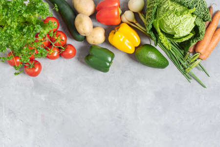 Variety of vegetables on grey concrete table top view. Healthy food background.