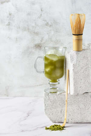 Green matcha iced tea in a long glass on modern balanced grey concrete background. Modern still life of matcha tea.の写真素材