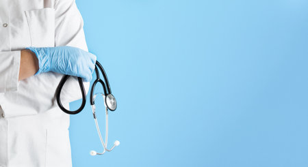 Doctor in a lab coat with stethoscope over blue background. Healthcare and medical concept.の写真素材