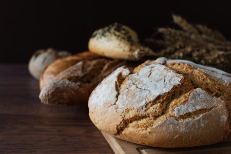 Loaf of sourdough bread with crispy crust on wooden background. Healthy organic bakery goods.の写真素材