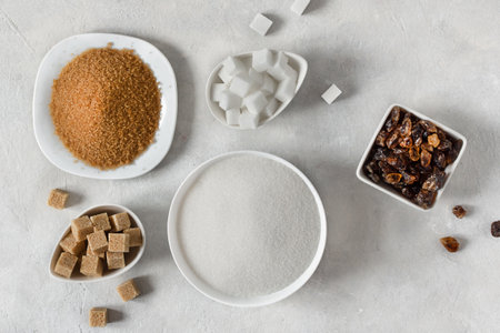 Various kinds of sugar. Different white and brown sugar in assortment top view on grey background.の写真素材