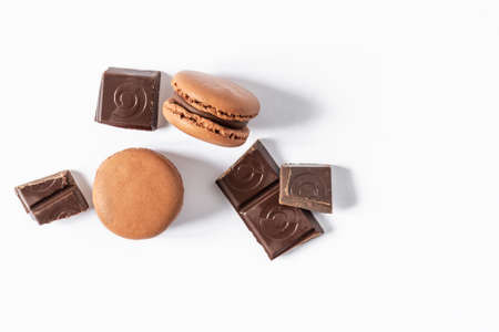 Chocolate macaroons dessert on white background top view. French meringue cookie macarons with chocolate pieces.の写真素材