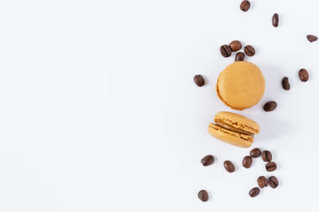 Coffee macaroons dessert on white background top view. French meringue cookie macarons with coffee beans.の写真素材