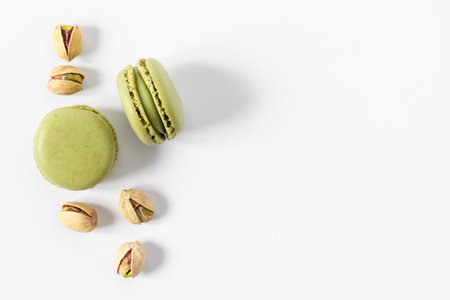 Pistachio macaroons dessert on white background top view. French meringue cookie macarons with pistachio nuts.の写真素材