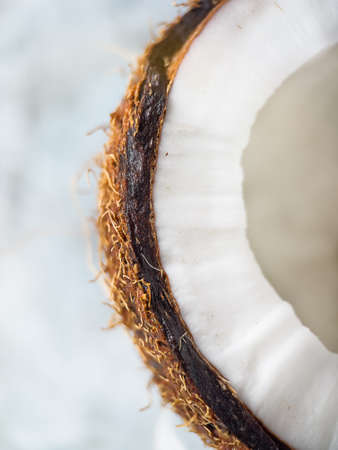 Half of coconut closeup over blue background. Macro photo of coconut.の写真素材