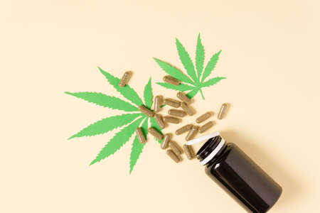 Cannabis capsules top view on yellow background. Alternative herbal medicine. Hemp pills. Medical marijuana.の写真素材