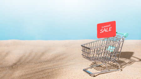 Shopping trolley cart on beach sand with red sale tag. Summer sale concept. Summer shopping.の写真素材