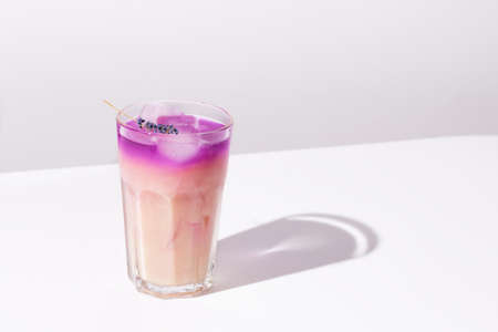Iced coffee lavender drink on white background. Lavender purple honey latte.の写真素材