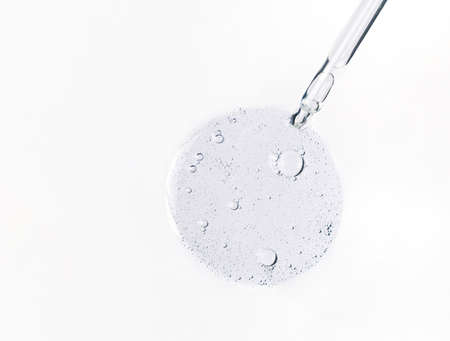 Cosmetic serum bubbles and dropper with hyaluronic acid on white background. Abstract drop of skin...