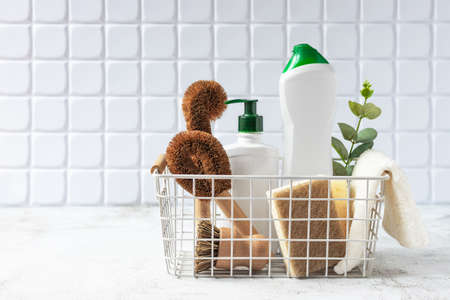 Natural brushes, sponges and eco detergent for cleaning in basket. Cleaning supplies over white.の写真素材
