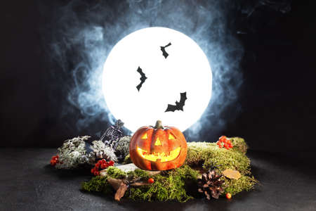 Halloween pumpkin Jack Oâ Lanterns glowing in spooky night over full moonlight. Halloween greeting card. Halloween scary still life.の写真素材