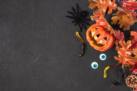 Halloween pumpkin Jack o Lantern and Halloween holiday candy and scary decorations on black background. Halloween background.の写真素材