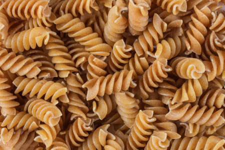 Organic raw gluten free buckwheat fusilli pasta background. Wholegrain gluten free macaroni. Food background.の写真素材