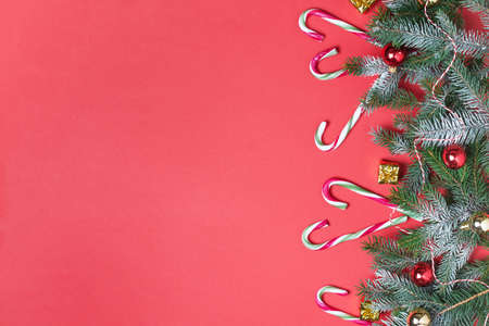 Christmas background with candy canes and Christmas tree on red. Christmas greeting card.
