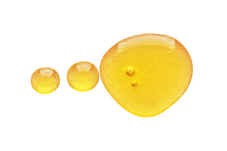 Golden yellow abstract oil bubbles or face serum drops isolated on white background. Oil bubbles macro photography.の写真素材