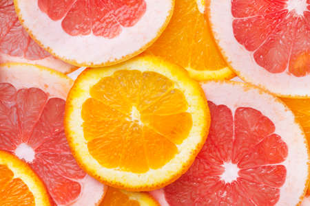 Round slices of citrus fruits top view. Citrus fruits orange and grapefruit background.の写真素材