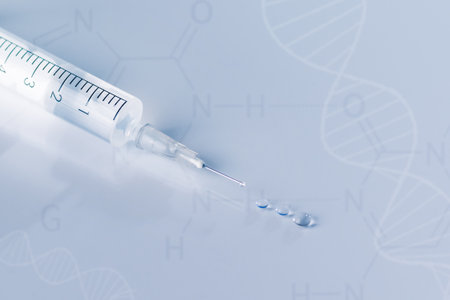 Syringe with injection over blue background. Vaccination or beauty therapy concept.の写真素材