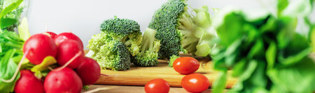 Fresh vegetables on wooden table. Cooking healthy salad with broccoli, tomato, radish and lettuce.の写真素材