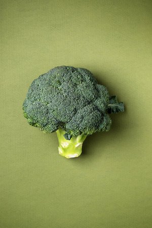 Fresh broccoli on green background. Whole raw broccoli cabbage wallpaper.