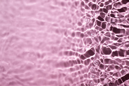 Pink water surface texture with splashes and bubbles. Abstract background for beauty products. Pink water splashes wallpaper.の写真素材