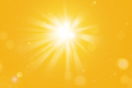 Bright sun with sun rays and lens flares on orange summer background. Sunny summer wallpaper.の写真素材